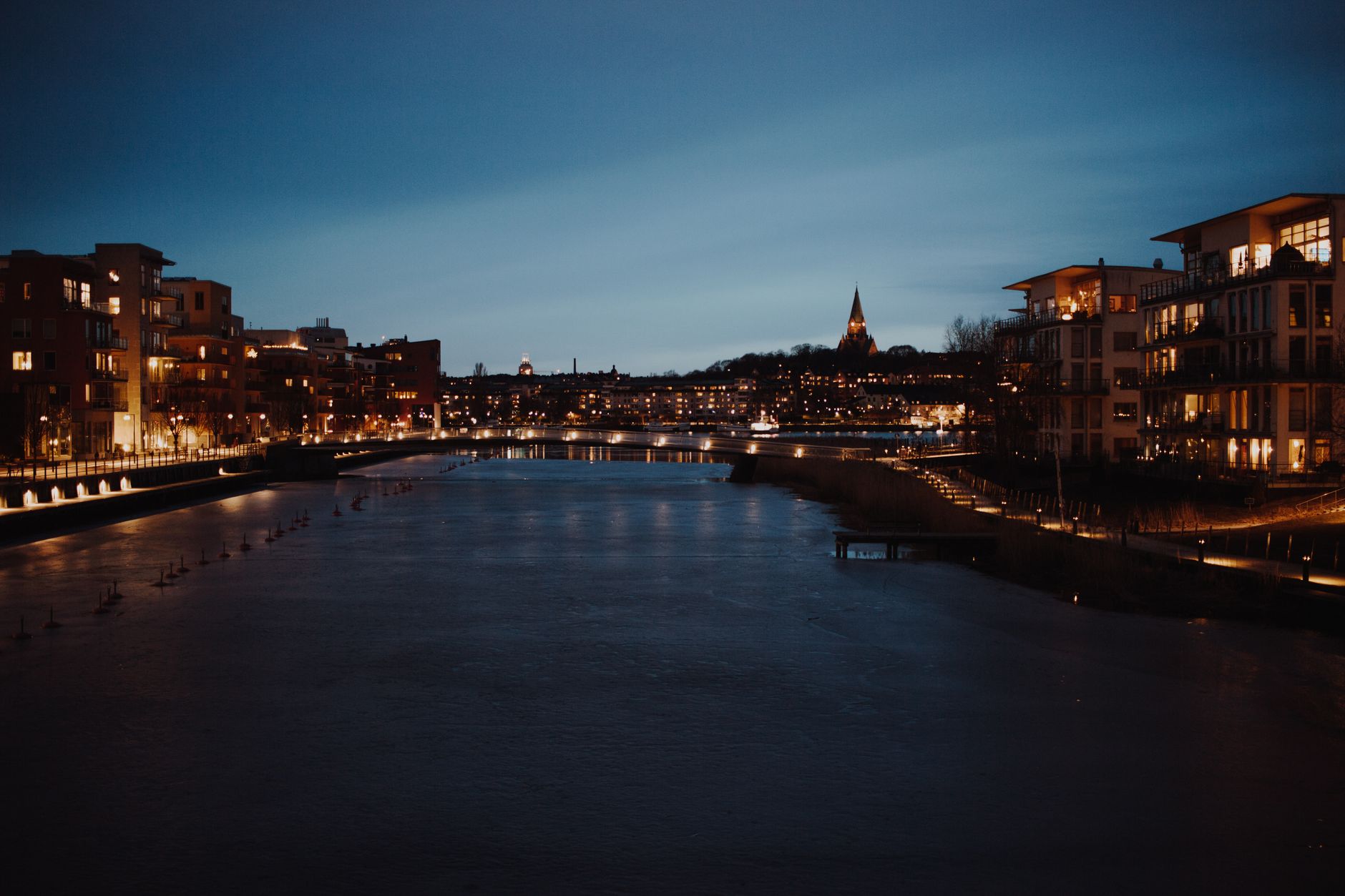 Byens bygninger spejler sig i en kanal om aftenen